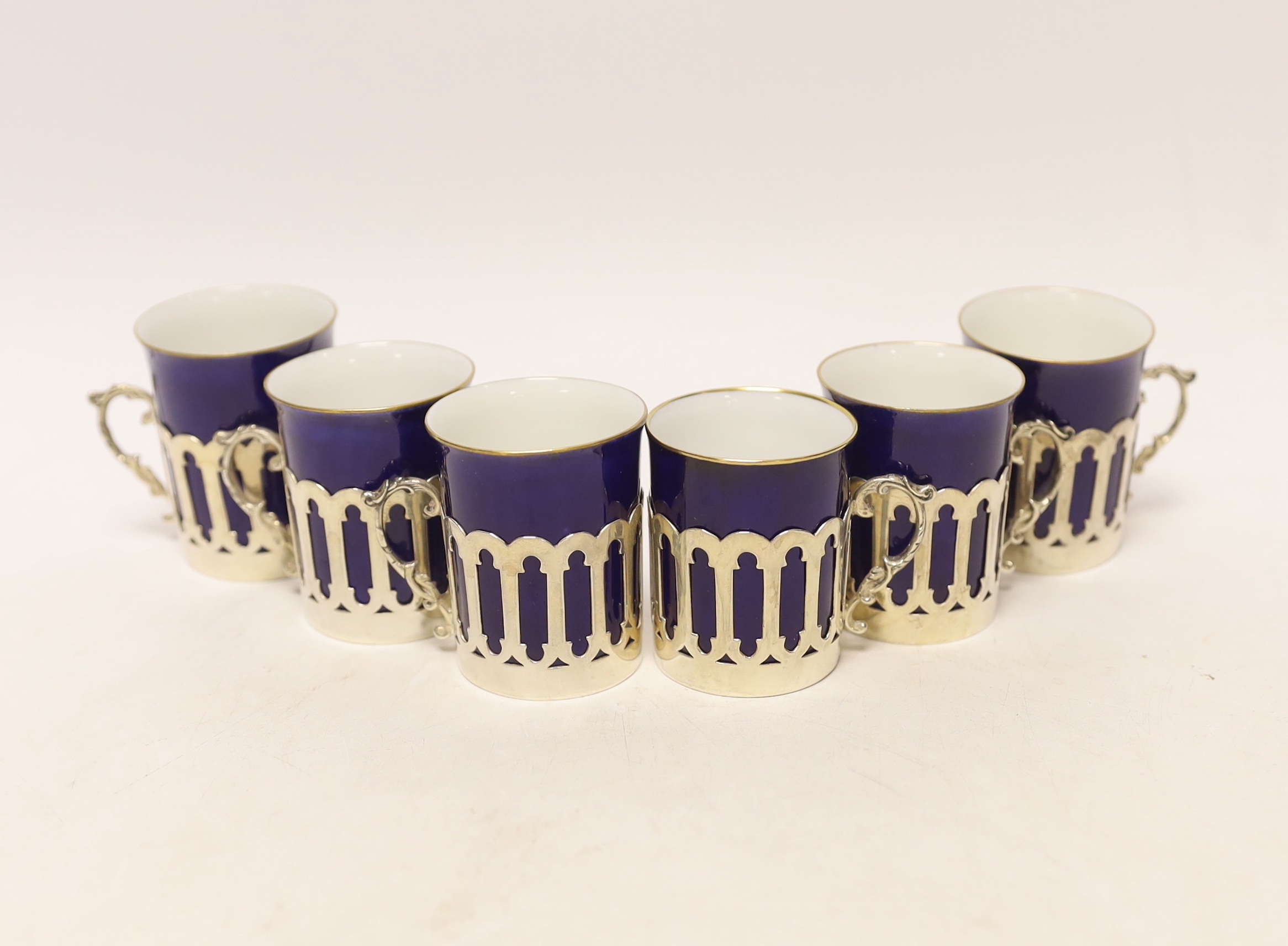 A set of six pierced silver handled coffee can holders, James Dixon & Sons, Sheffield, 1911, with six Crescent China coffee cans